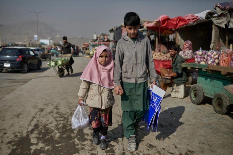 Ten-year-old Matiullah, and his eight-year-old sister, Hajira, sell plastic bags in the market near their home