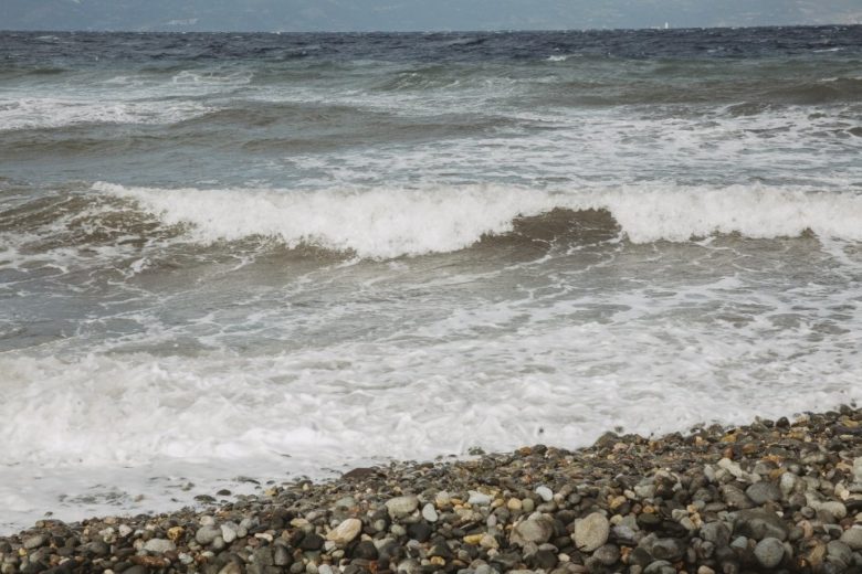 Les vagues de l'océan s'écrasent sur une plage rocheuse.