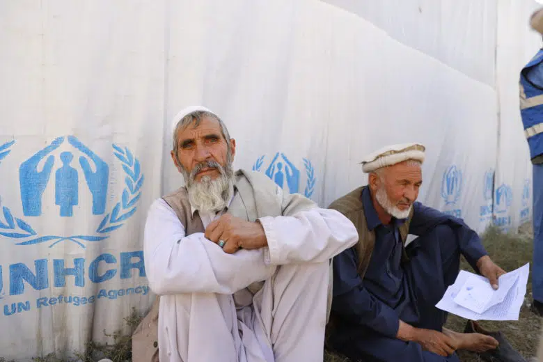 Afghanistan - two men sitting. As winter looms, UNHCR distributes cash and aid to displaced in Kabul.