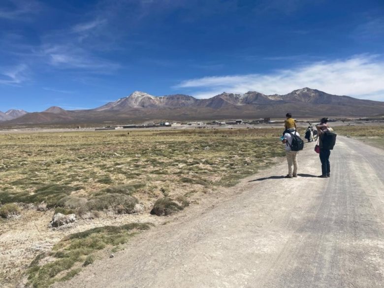 A few people looking into Chilean mountains as they cross the Bolivian-Chilean border.