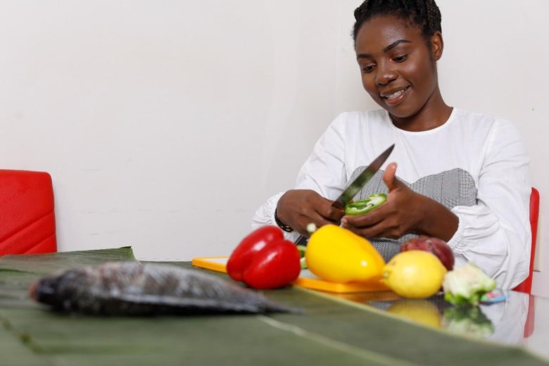 Twenty-two-year-old refugee, Anuarite Manyoha, chopping vegetables