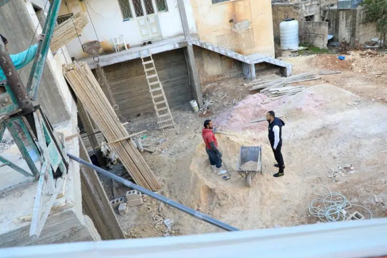 Two men working on building a shelter.