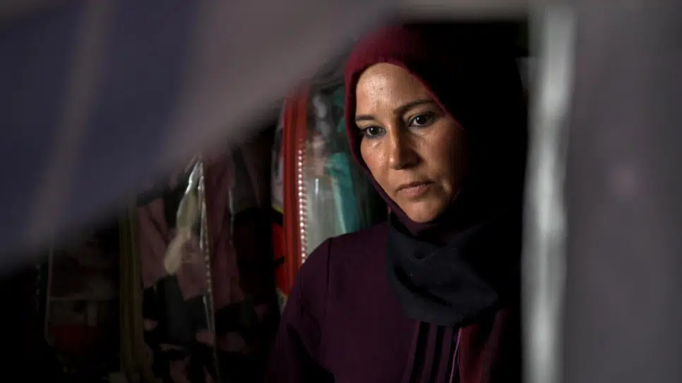 woman wearing a burgundy hijab staring down 