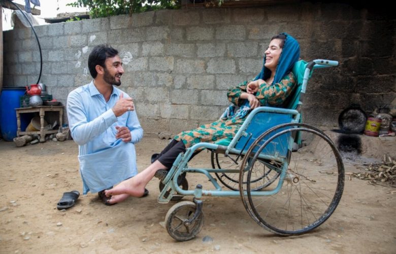 man laughing with woman in wheelchair