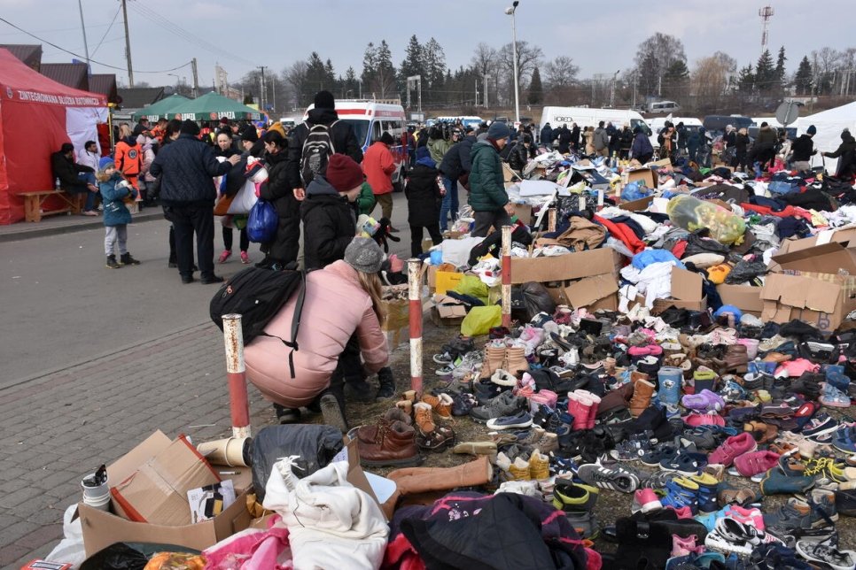 Roadway with boxes of donated items like shoes and jackets laid on the ground for refugees.