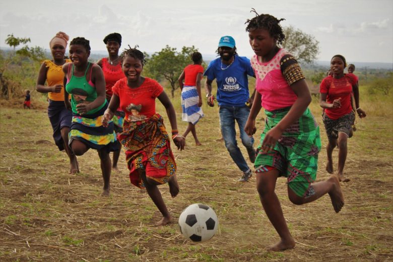 People playing soccer with UNHCR staff.