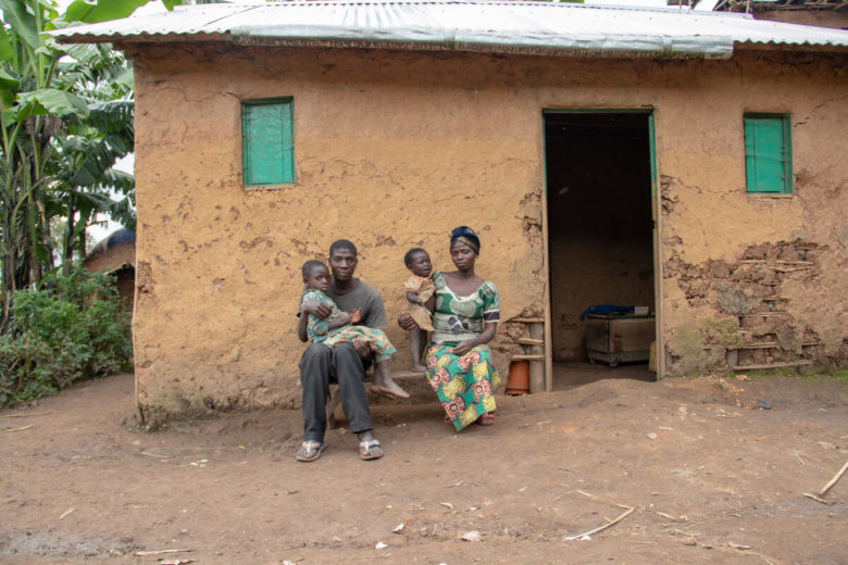 Obed*, 25 ans, qui a été blessé par balle lors d’une attaque en 2020 assis avec sa famille devant leur maison à Kibarizo.
