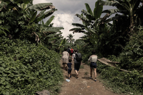 People walking on a forested path.