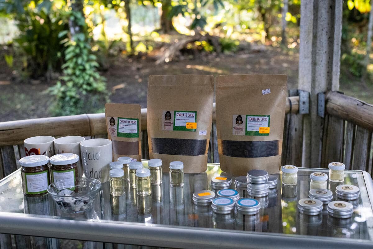 Various bagged and jarred products on glass display case with tropical trees behind them