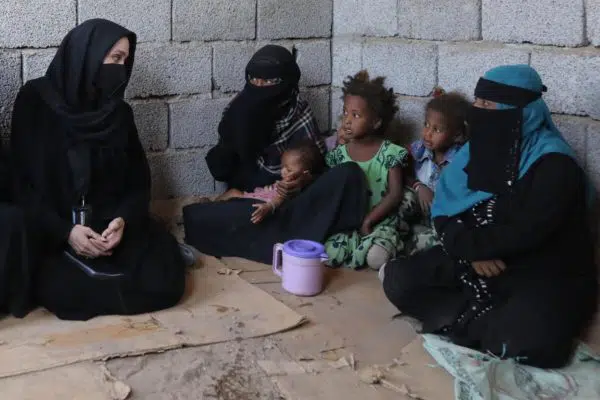 Angelina Jolie sitting with a family from Yemen