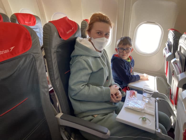 Une mère et son enfant mangent un repas dans un avion.