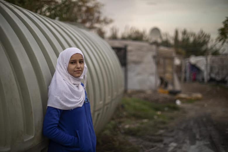 12 year old girl standing next to temporary shelter