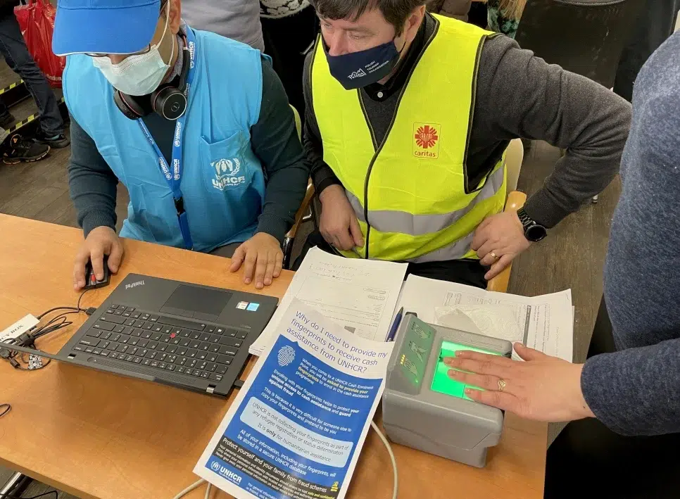 UNHCR Staff looking at computer and processing cash assistance