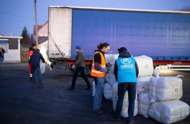 UNHCR staff unload thermal blankets