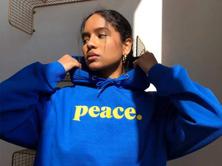 Woman wearing blue hoodie with the words peace