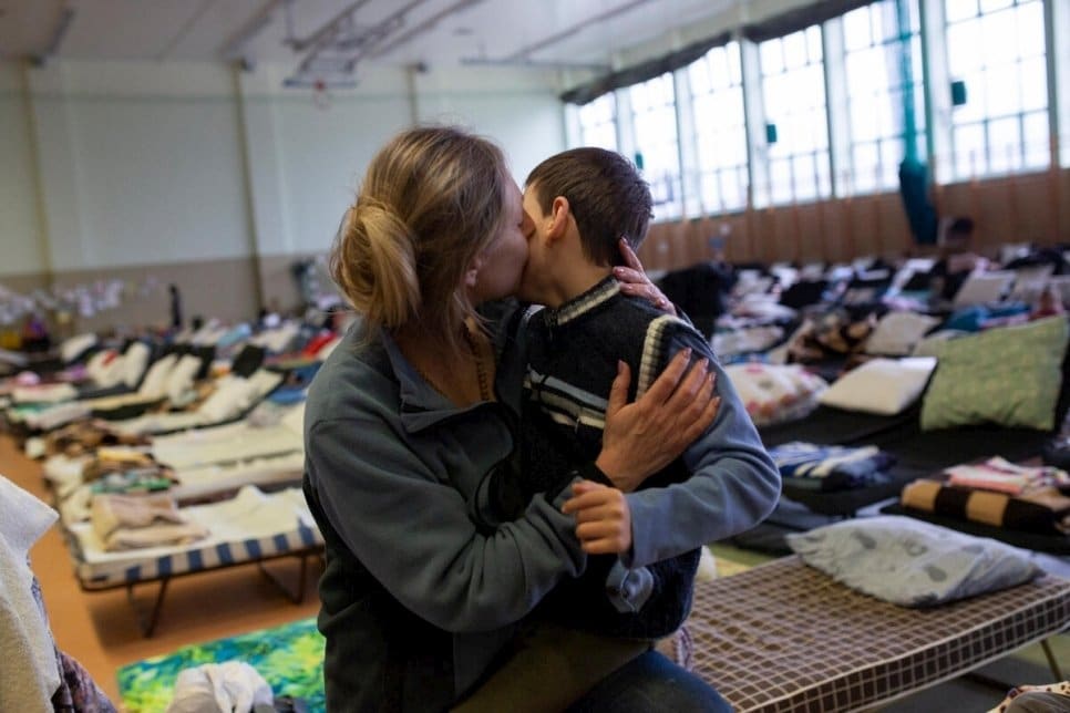 Une mère réfugiée ukrainienne tenant son fils dans un refuge.