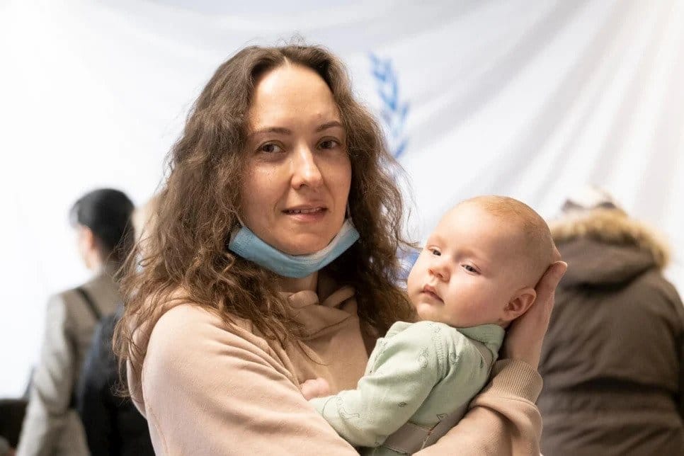 Refugee woman holding her baby.