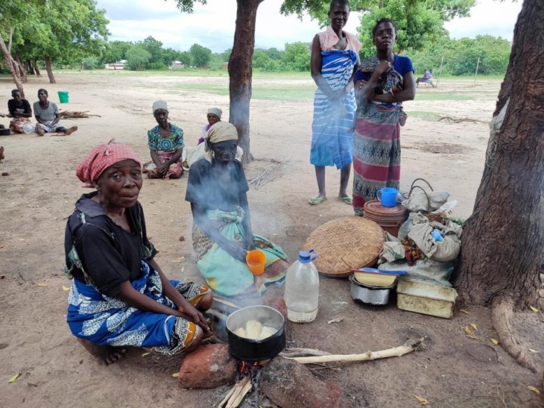 Femme âgée cuisinant à l'extérieur d'une école primaire au Malawi.