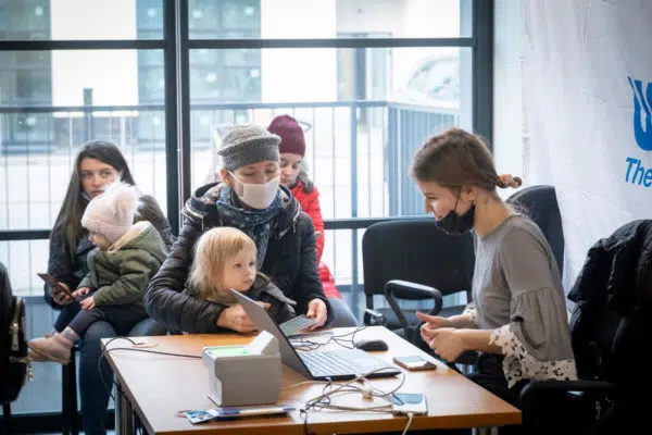 Ukrainian Refugees registering, focus on mother and her young child.