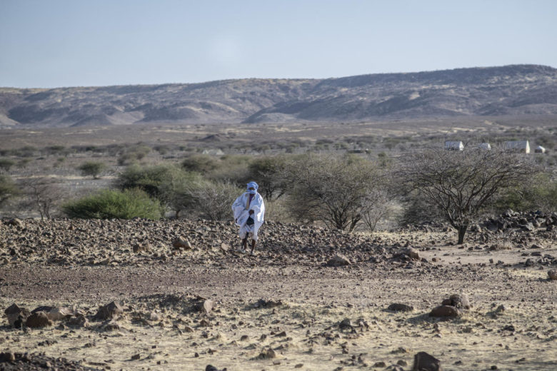 A Burkinabe man walks across the arid land near Kaya, Burkina Faso.