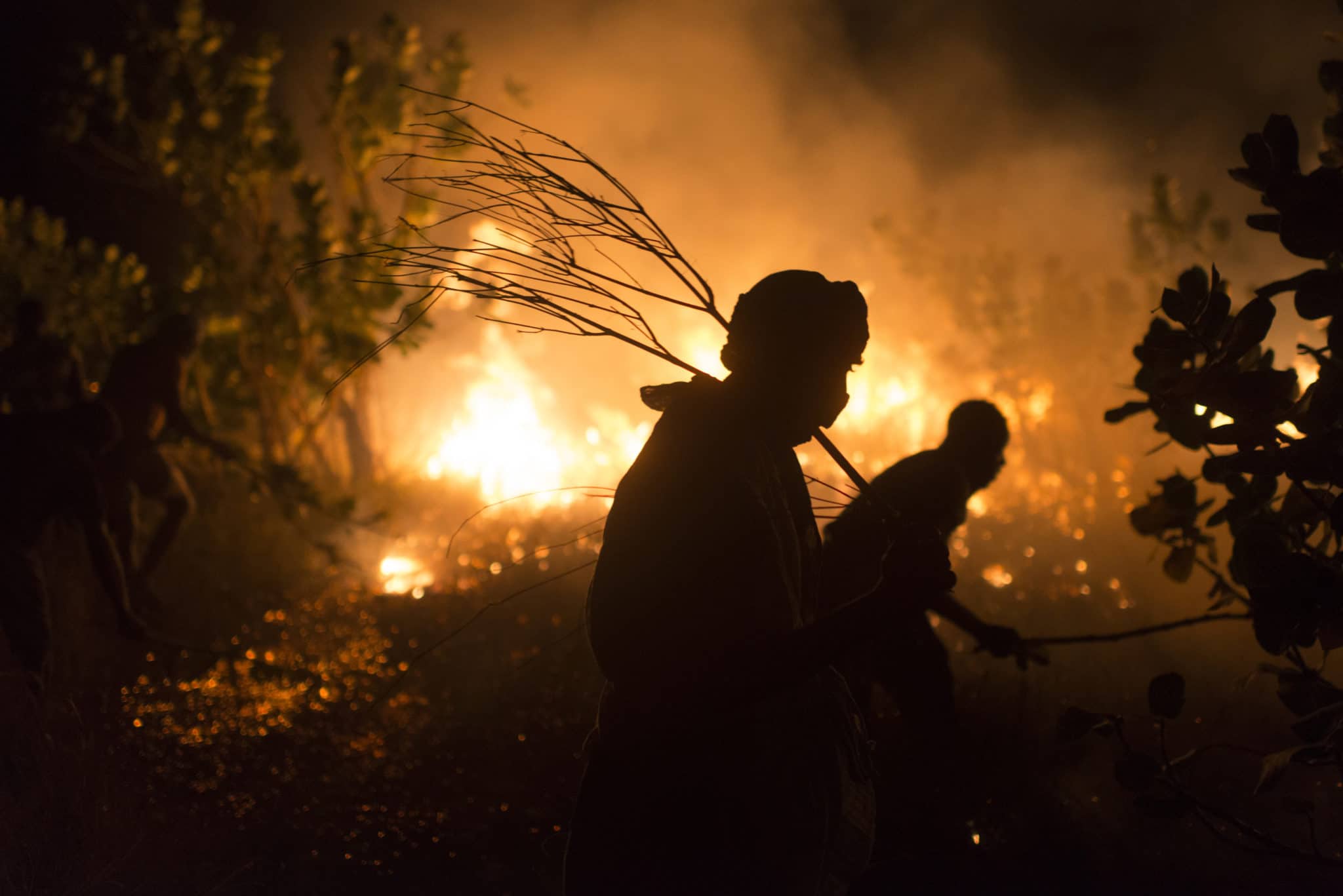 Silhouette of people against a wild fire