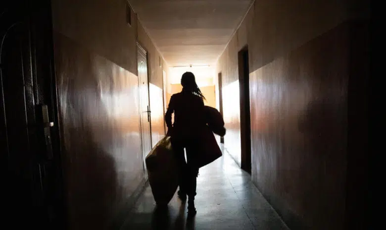 Woman walking down a dark hallway