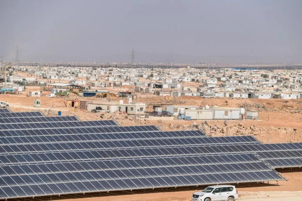 overhead view of solar panels next to a camp in the desert