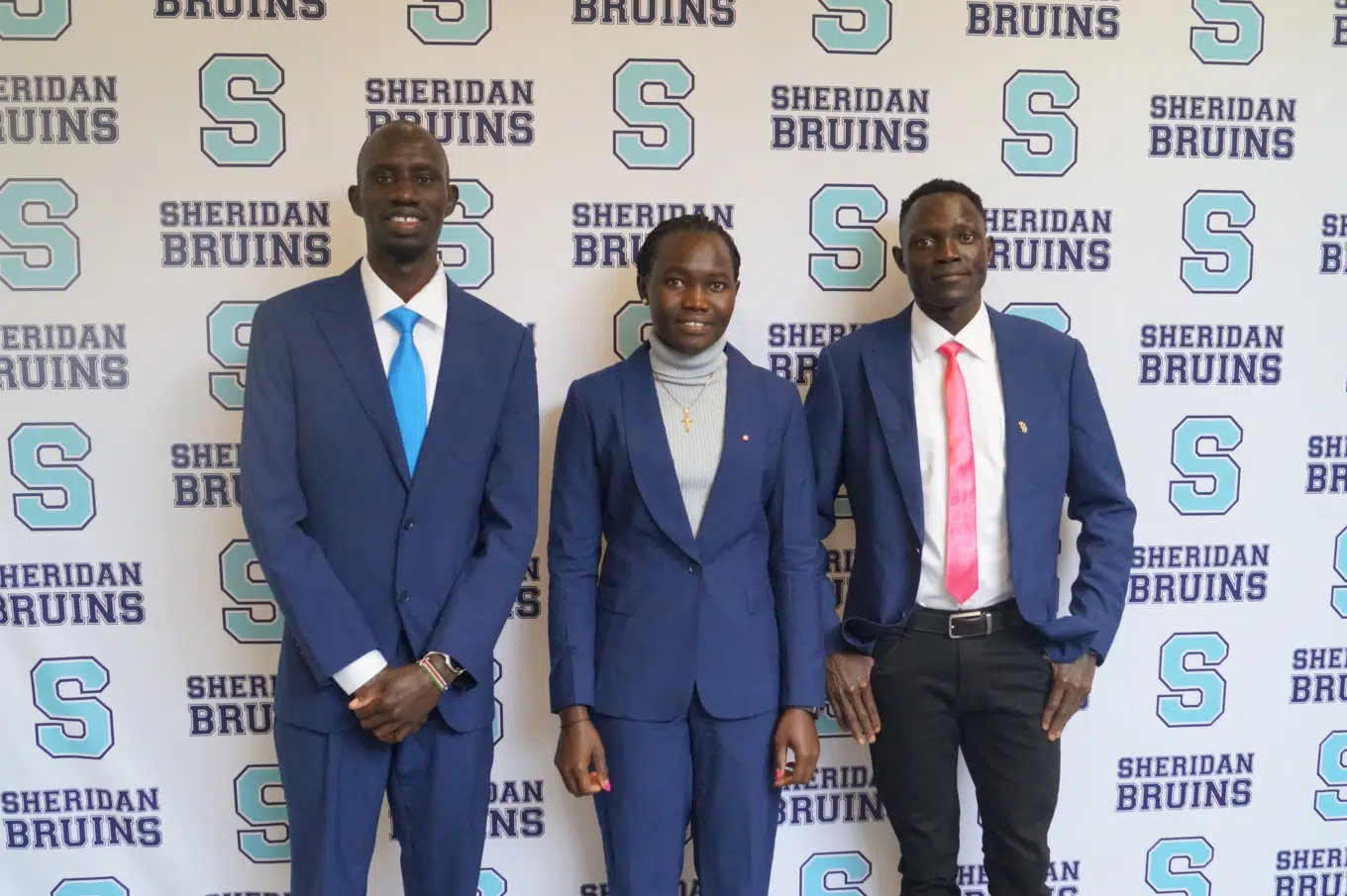 Photo of three people in front of Sheridan Bruins backdrop.