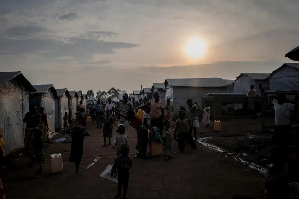 sunsetting over a refugee camp that is still busy with people 