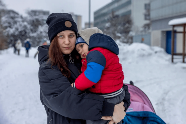 Kateryna avec son fils de 2 ans. Elle et sa famille ont fui l’Ukraine pour se rendre en Pologne en mars 2022. Ils célébreront le Noël orthodoxe dans un centre d’hébergement à Cracovie, où ils partagent un dortoir avec une trentaine de personnes. © HCR/Anna Liminowicz