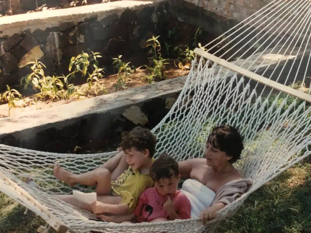 Two children and mother lay in hammock.