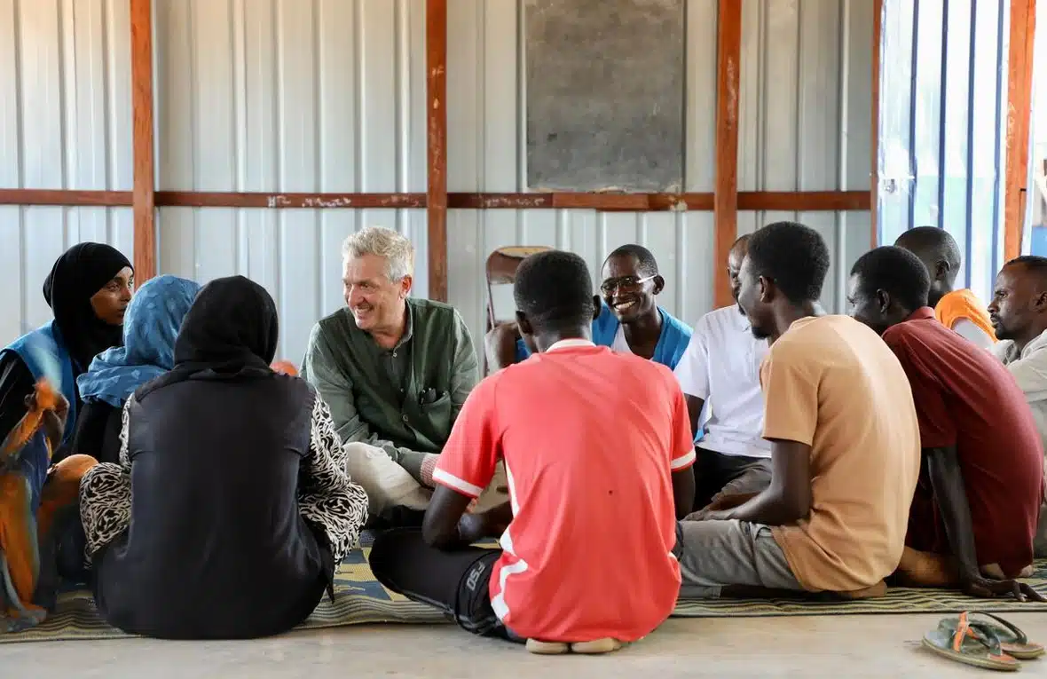 People sit around in a circle on the floor.