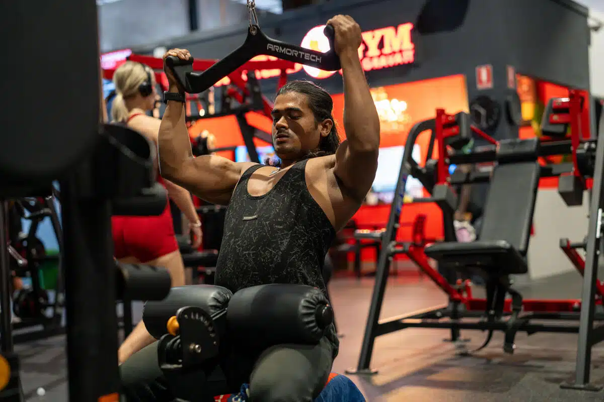 A man using a cable machine (lat pulldown) at the gym