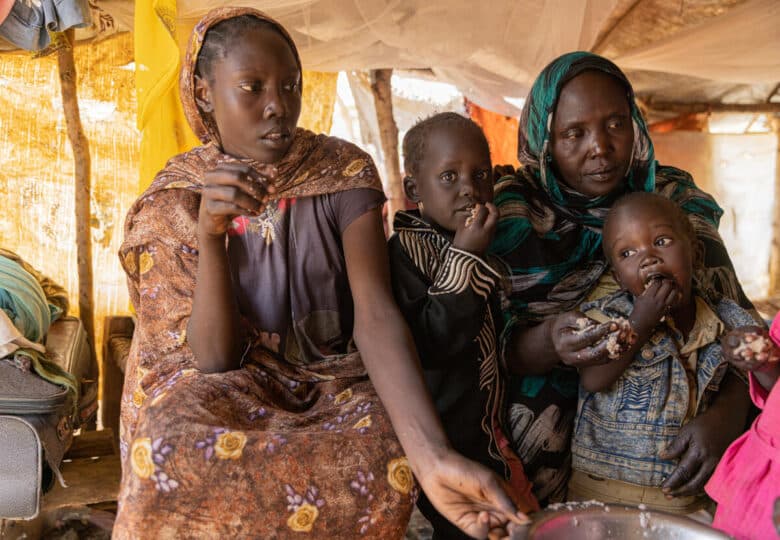 An older woman and three children eat.