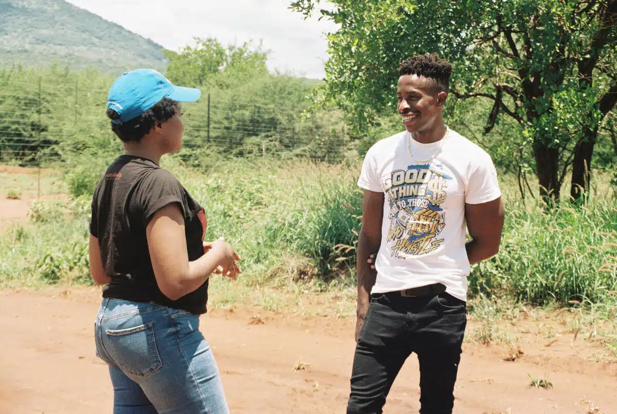 A man and a woman look at each other, standing and talking