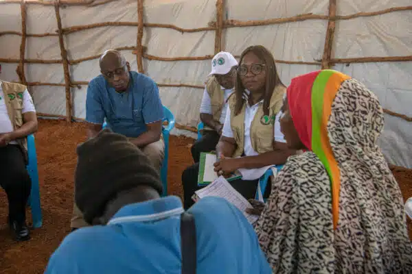 UNHCR's Assistant High Commissioner, Raouf Mazou, sits with four people around her