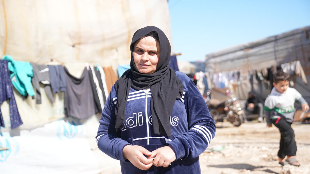 close up of a woman standing in a refugee camp 