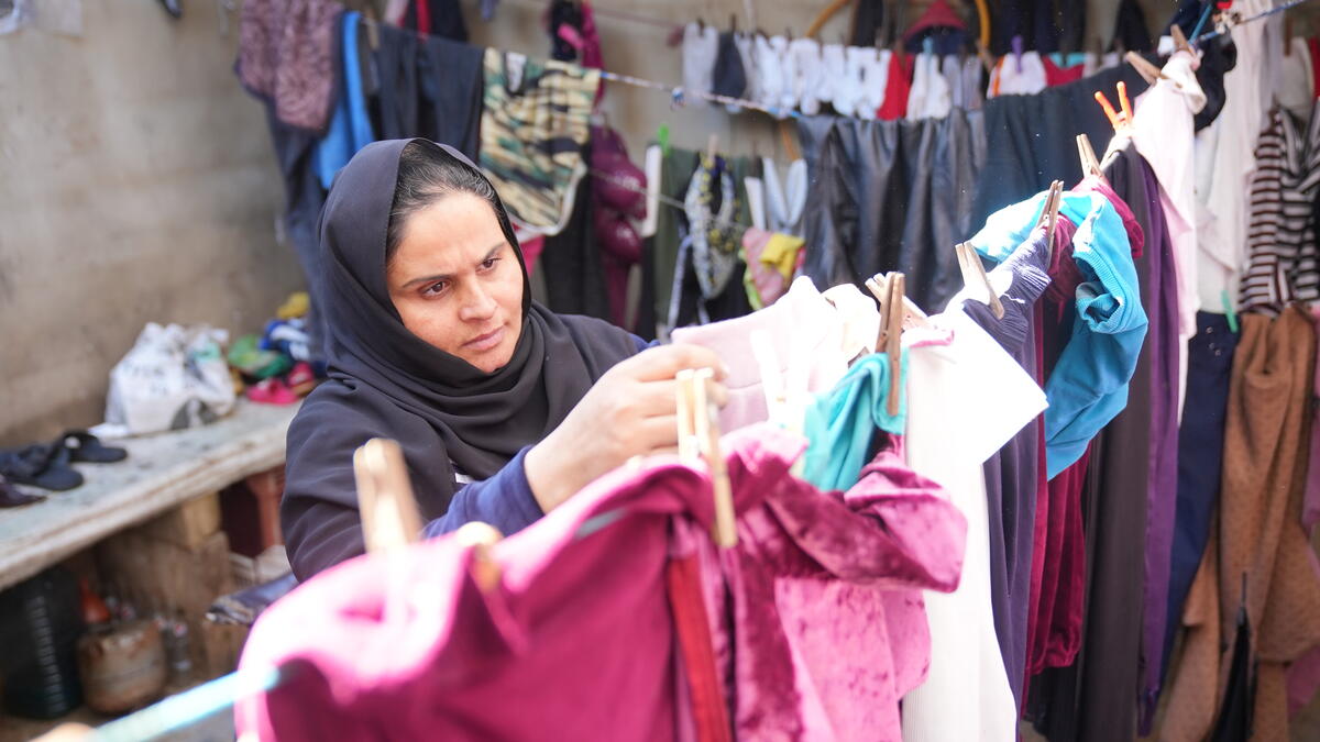 A woman hanging clothes on a clothesline