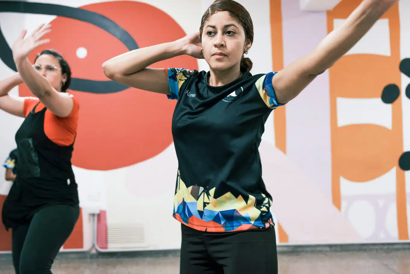 A woman dancing with her arms over her head 