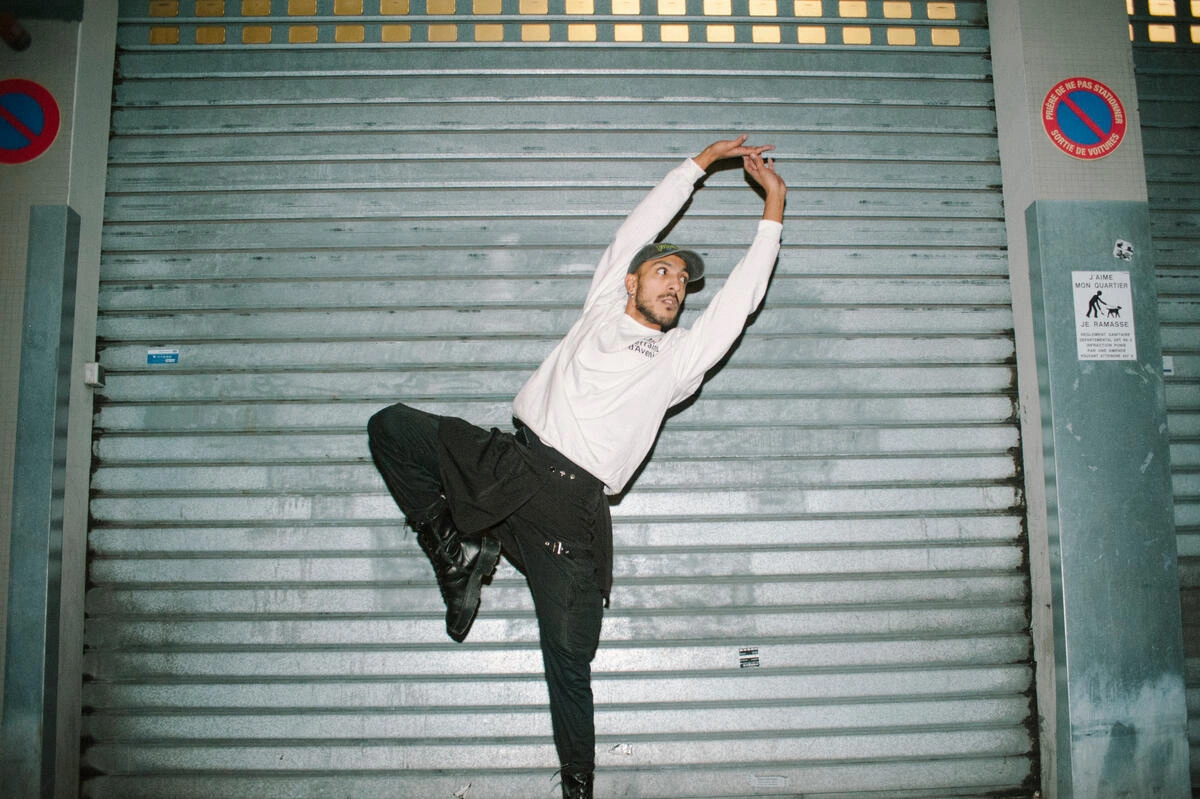 Un homme fait un mouvement de danse, apparemment un mouvement de ballet.