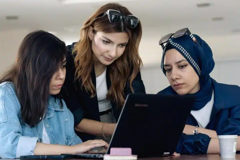 Trois femmes travaillent, le regard fixé sur un écran d'ordinateur.