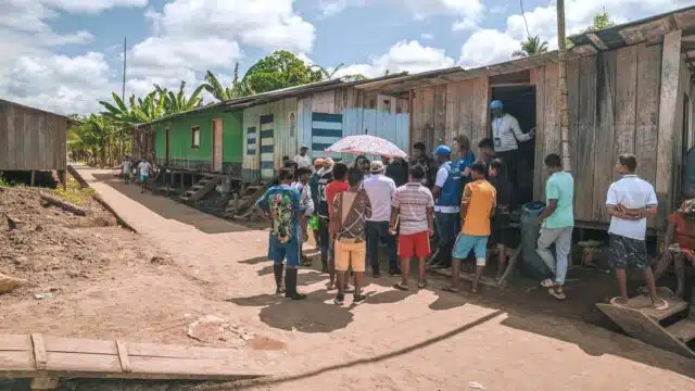 A group of internally displaced people speak with UNHCR officials outside a row of