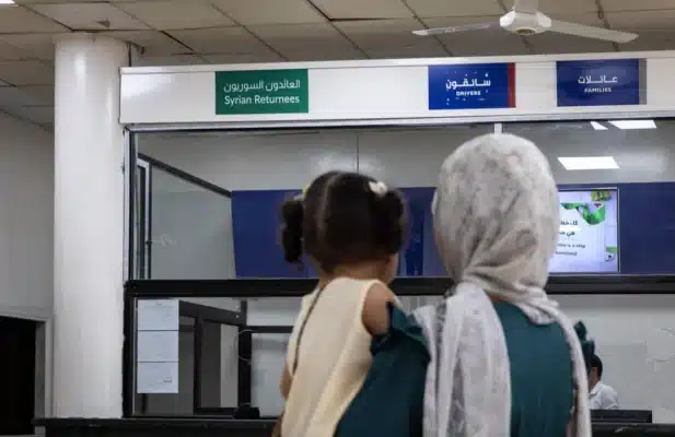 A woman carrying her daughter are facing a border