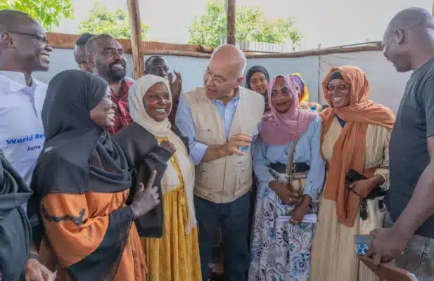UN High Commissioner for Refugees Barham Salih stands surrounded by smiling women and men dressed in colourful dresses in Ethiopia's Ura camp on World Refugee Day.