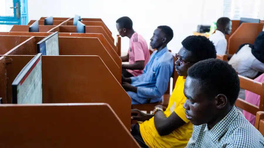 A group of Sudanese refugees are seen sitting at computer desks at a connectivity centre in Farchana refugee settlement, Chad.