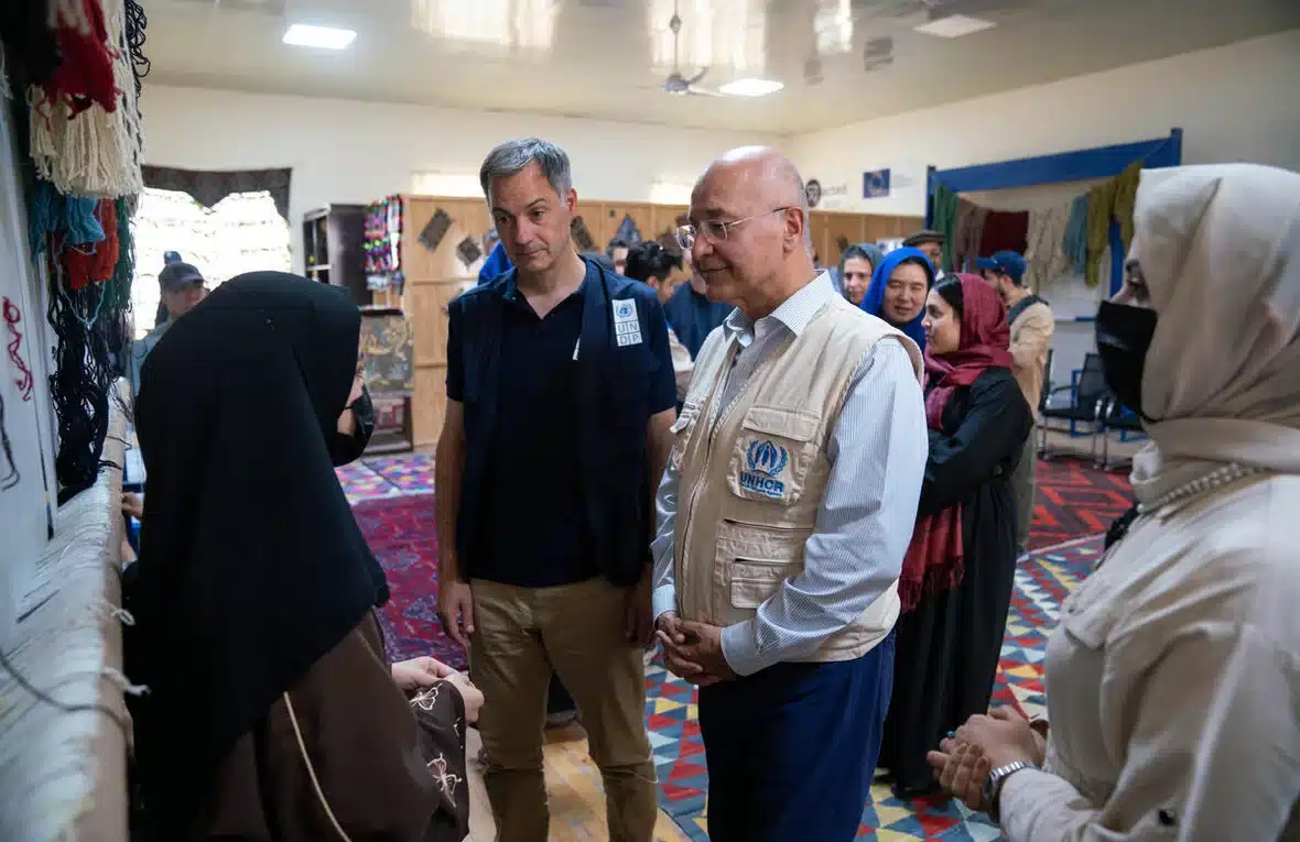 UNDP Administrator Alexander De Croo (centre left) and UNHCR chief Barham Salih (centre right) are seen speaking with a veiled woman at a carpet weaving centre in Mazar-e-Sharif, Afghanistan, that helps women earn a living.